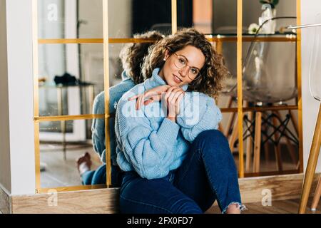 Beautiful young African American female with curly hair looking at camera while standing on the street Stock Photo