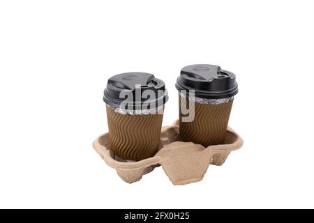 Disposable paper coffee cups with black caps on cardboard stand isolated on white background. Takeaway coffee. Stock Photo