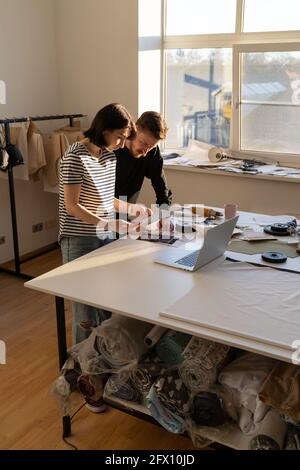 Clothes designers team choose material for sewing new collection. Dressmakers work in design studio Stock Photo