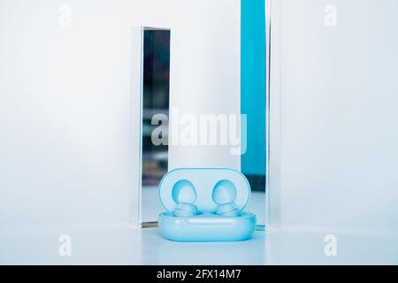 Wireless blue earbuds with prism background Stock Photo