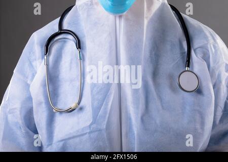 Mid section of health worker wearing protective clothes against grey background Stock Photo