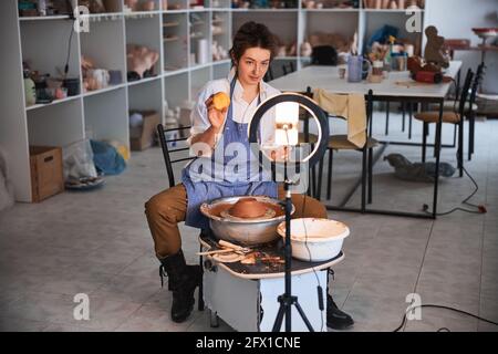 Glad woman potter having a break with fruit Stock Photo
