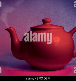 red teapot set against a purple and red background Stock Photo