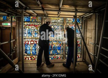 Conservator Matthew Nickels (left) and Master Glazier Tony Cattle (right) from York Glaziers Trust removed a stained glass window panel at the start of a new five year, £5m project to conserve York Minster's South East Transept and its medieval St Cuthbert Window. Picture date: Tuesday May 25, 2021. Work is being undertaken by York Glaziers Trust to remove stained glass panels from the window, which is nearly 600-years-old and one of the largest surviving narrative windows in the world. The project involves major conservation and restoration works to both the stained glass and stone elements o Stock Photo