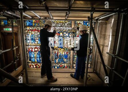 Conservator Matthew Nickels (left) and Master Glazier Tony Cattle (right) from York Glaziers Trust removed a stained glass window panel at the start of a new five year, £5m project to conserve York Minster's South East Transept and its medieval St Cuthbert Window. Picture date: Tuesday May 25, 2021. Work is being undertaken by York Glaziers Trust to remove stained glass panels from the window, which is nearly 600-years-old and one of the largest surviving narrative windows in the world. The project involves major conservation and restoration works to both the stained glass and stone elements o Stock Photo