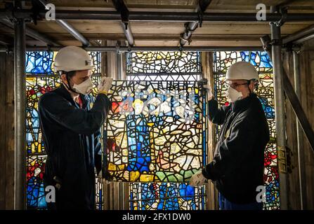 Conservator Matthew Nickels (left) and Master Glazier Tony Cattle (right) from York Glaziers Trust removed a stained glass window panel at the start of a new five year, £5m project to conserve York Minster's South East Transept and its medieval St Cuthbert Window. Picture date: Tuesday May 25, 2021. Work is being undertaken by York Glaziers Trust to remove stained glass panels from the window, which is nearly 600-years-old and one of the largest surviving narrative windows in the world. The project involves major conservation and restoration works to both the stained glass and stone elements o Stock Photo