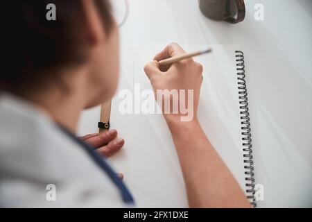 Person drawing on paper sheet with pencil Stock Photo
