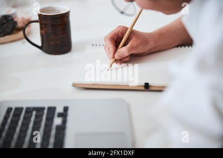 Pencil in person hand drawing animal on paper Stock Photo