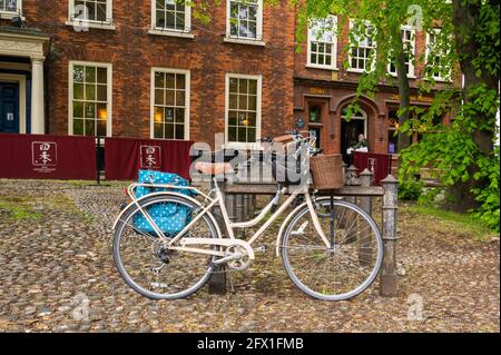 Old style ladies bicycle locked to a  metal rail in Tombland norwich on a cobbold part of the walkway Stock Photo