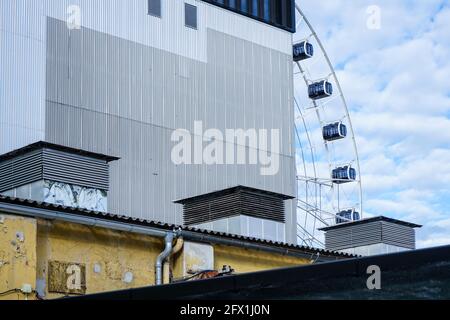 Triad with the roof of an old industrial building, a new building and a Ferris wheel at Werksviertel Munich. Stock Photo