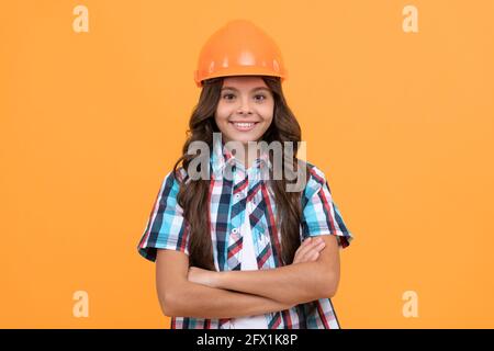 making repairs. happy teen girl in protective hard hat. child wear helmet for building. Stock Photo