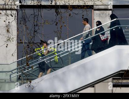 London, England, UK. Muslim family passing as man carying his bike up steps to the Golden Jubilee Bridge in Northumberland Avenue Stock Photo