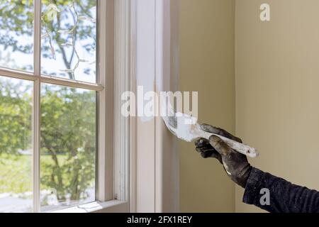 Handyman paints a window molding frame at home Stock Photo