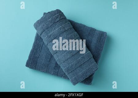 Clean folded towels on blue background, top view Stock Photo