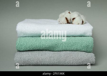 Clean folded towels with cotton on gray background Stock Photo