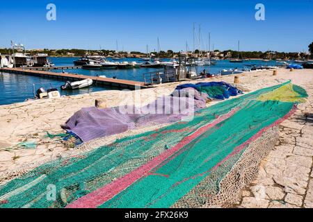 Porto Cristo, Spain. 24th May, 2021. Colourful fishing nets lie in the harbour of Porto Cristo in the east of the island of Mallorca. Not many tourists have arrived on the island so far. German travelers are allowed to travel to Spain without quarantine obligation. Travelers from Germany are required to show a negative PCR test when entering by air or sea. Spain has announced relaxations for vaccinated and convalescents. Restaurants and cafes on Mallorca are open again. Credit: Jens Kalaene/dpa-Zentralbild/ZB/dpa/Alamy Live News Stock Photo