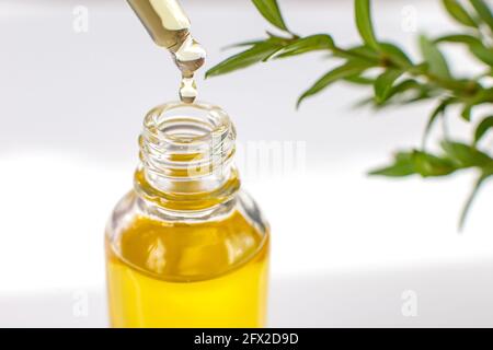 Close up essential or organic oil in a glass pipette, over a bottle