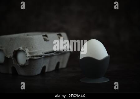 white egg on a stand on a dark background Stock Photo