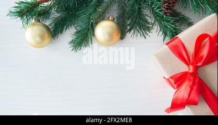Decorated fir branch on tree with Gift box on wood background. Space for text Stock Photo