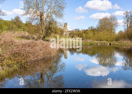 The ruins of St Martins church reflected in an abandoned mill pond at Wharram Percy Deserted Medieval Village on the Yorkshire Wolds, North Yorkshire, Stock Photo