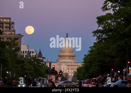 The last rays of the sun set on the United States Capitol Building as the moon rises over Washington, D.C. Stock Photo