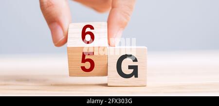 Businessman hand change wooden block from 5G to 6G (Generation of Cellular Mobile Communications) Technology, network, Social media and digital concep Stock Photo
