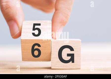 Businessman hand change wooden block from 5G to 6G (Generation of Cellular Mobile Communications) Technology, network, Social media and digital concep Stock Photo