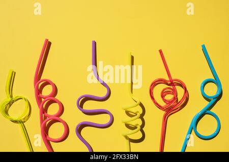 Set of Spiral multicolor cocktail tubes, isolated on yellow background.party drinking straw. Stock Photo