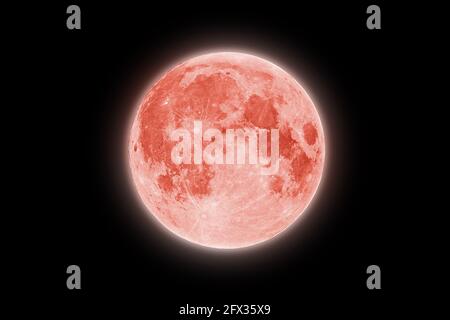 Full red strawberry supermoon halo glowing on black night sky background Stock Photo