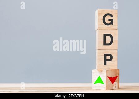 wood cube block with GDP text (Gross domestic product) to UP and Down arrow symbol icon. Financial, Management, Economic and business concepts Stock Photo