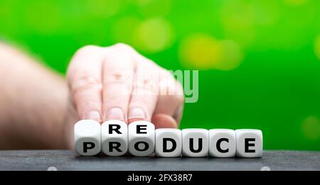 Hand turns dice and changes the word "produce" to "reduce". Stock Photo