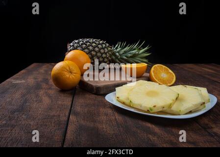 pineapple slices in a white crockery on a rustic wooden surface. Selective focus Stock Photo
