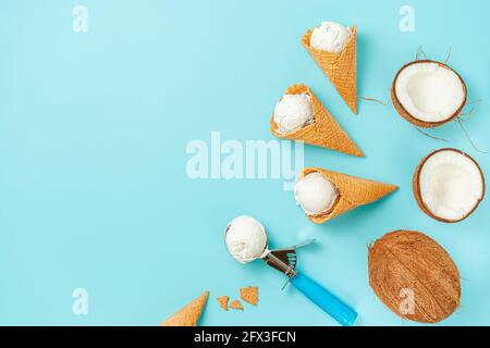 Waffle ice cream cones with coconuts on blue background. Top view, copy space. Stock Photo