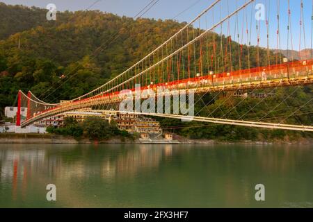 Ram jhula bridge of Rishikesh over Holy river Ganges, a suspension bridge famous for association with Hindu mythology God Ram , Uttarakhand, India Stock Photo