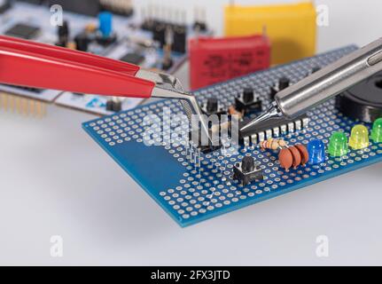 Detail of holding an electronic component with a tweezer  while soldering Stock Photo