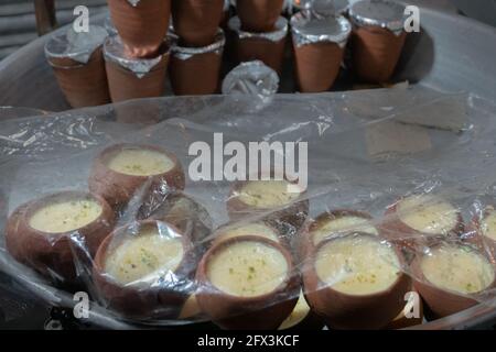 Rabri in clay containers for sale. Rabri is a sweet, condensed-milk-based dish of India. Sugar, spices and nuts added to it to give it flavor. It is c Stock Photo