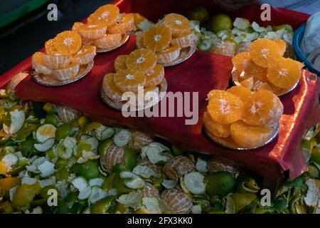 Half cut orange for sale as street food. Orange is a fruit of the citrus species , It is also called sweet orange which is widely consumed in India Stock Photo