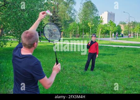 Father and son playing badminton on the lawn in the park Stock Photo