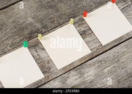 Square stickers pinned in a row on a wooden table. The concept of setting goals and objectives Stock Photo