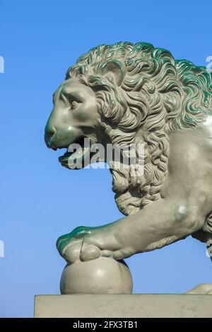 Old sculpture of a lion (1832) at the Palace pier close-up against the blue sky. Saint-Petersburg, Russia Stock Photo