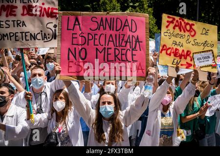 Madrid, Spain. 25th May, 2021. Protesters holding placards expressing their opinion, on Paseo de la Castellana street, during the demonstration. Hundreds of Resident Internal Doctors (MIR) have protested in front of the Spanish Ministry of Health, to show their rejection of the new requirements for the choice of specialized health training places and demand the resignation of the Minister of Health, Carolina Darias. Credit: SOPA Images Limited/Alamy Live News Stock Photo