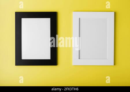 Two frames White and black photo frame on yellow background with free space. Minimalistic concept Stock Photo