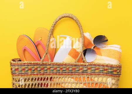 Bag with beach accessories on a yellow background close-up. Stock Photo