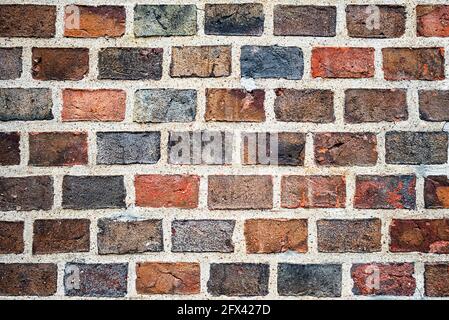 Old masonry of multicolored bricks in different shades of red and black Stock Photo