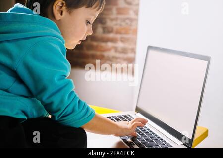 Little boy looking in amazement at a laptop. Stock Photo