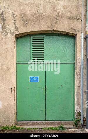 Green painted metal doors to warehouse building Stock Photo