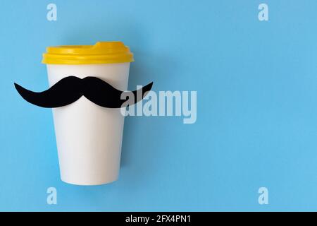 happy father day concept, black mustache on paper cup for coffee on blue background with empty space for text Stock Photo