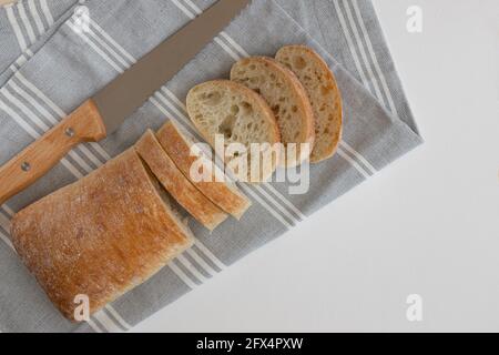italian ciabatta bread, food closeup, fresh homemade bread, unleavened bread, ciabatta bread and knife on towel isolated on white background Stock Photo