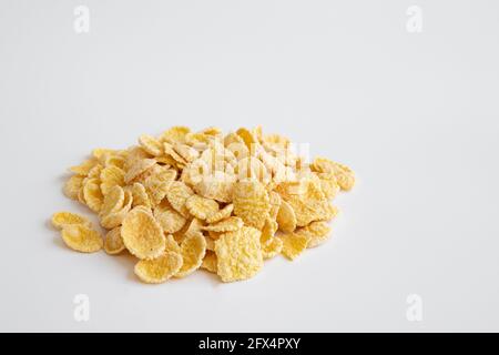 corn flakes isolated on white background, food ingredient, yellow corn cereal for breakfast, heap of sugar coated corn flakes cut out, side view Stock Photo