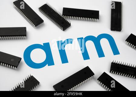 ARM company logo on the paper document and large microchips placed around. Illustrative for electronic chip manufacturer.  Selective focus. Stafford, Stock Photo